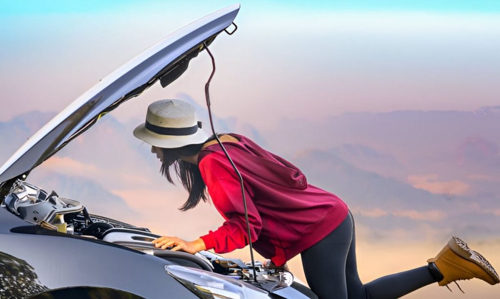Woman trying to fix engine start failure during a countryside road trip – essential car checks before a long journey